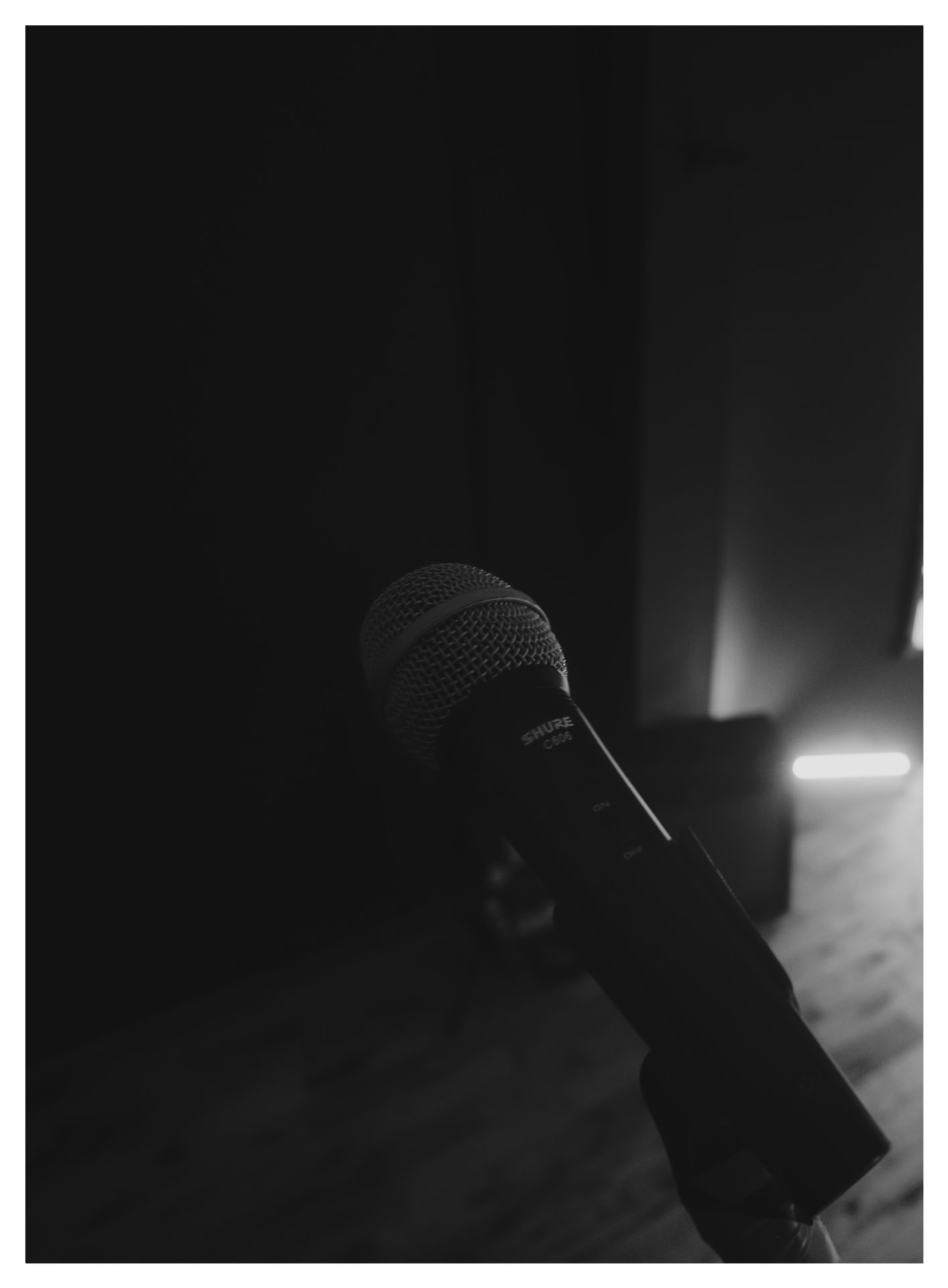 A black and white photograph of a Shure microphone in the studio